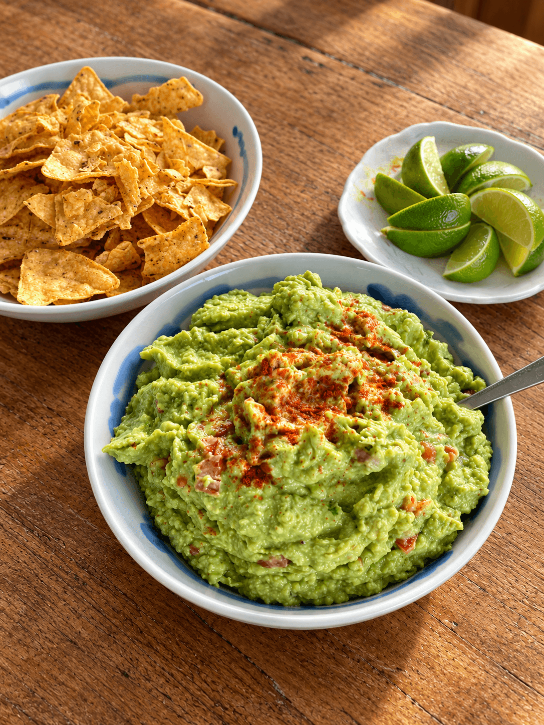 Guacamole with diced tomato and a pinch of smoked paprika in a bowl