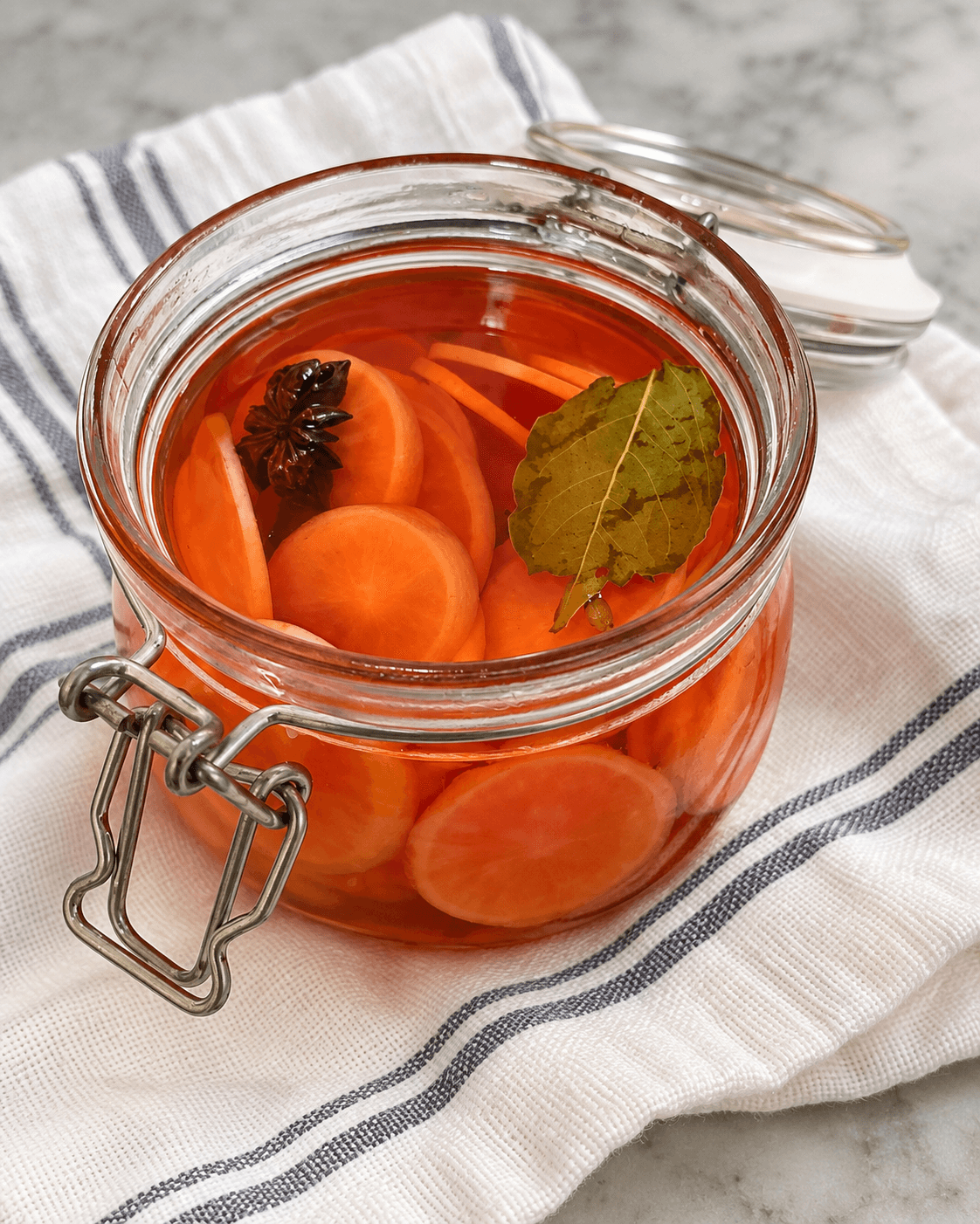 Pickeld radishes in a jar with star anise and a bay leaf